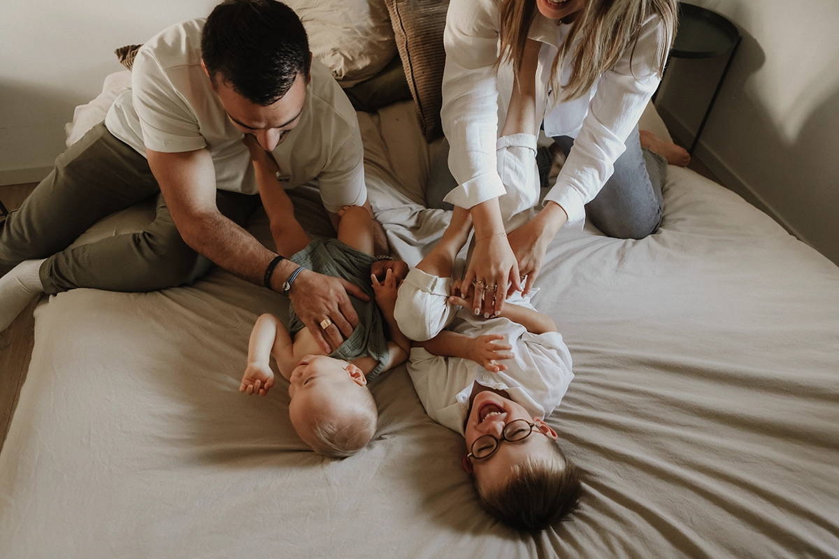 Des parents jouent avec leurs enfants, et les enfants rient.