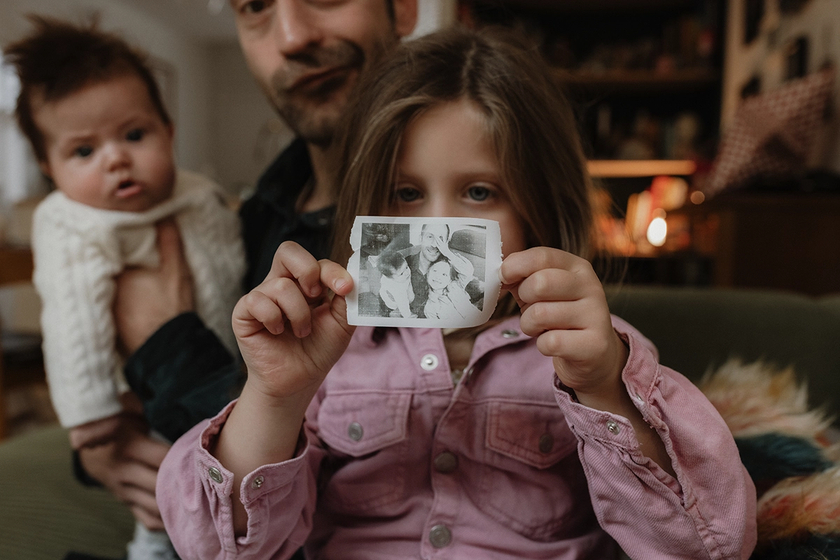 Une enfant montre une photo qu'elle a fait de sa famille.