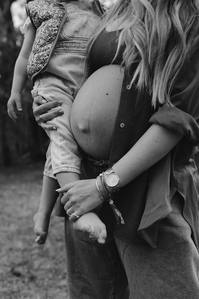 Une maman enceinte tient dans ses bras sa fille.