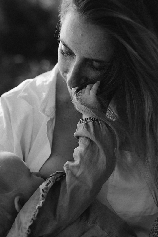 Allaitement d'un bébé qui tient dans sa main les cheveux de sa mère.