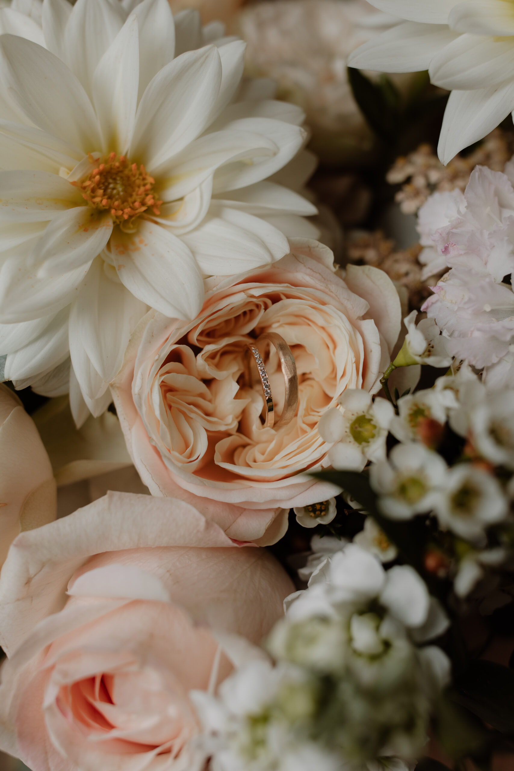 Gros d'une alliance posée au coeur d'une rose du bouquet de la mariée.
