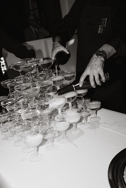 Un serveur verse du champagne dans les verres empilés pendant la soirée.
