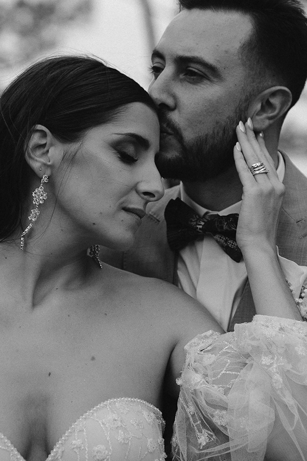 Une mariée de dos va rejoindre le mariée pour la découverte, son voile vol en l'air.