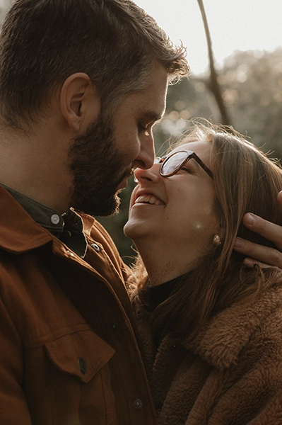 Un couple au coucher du soleil dans un parc de Toulouse se prend dans les bras.