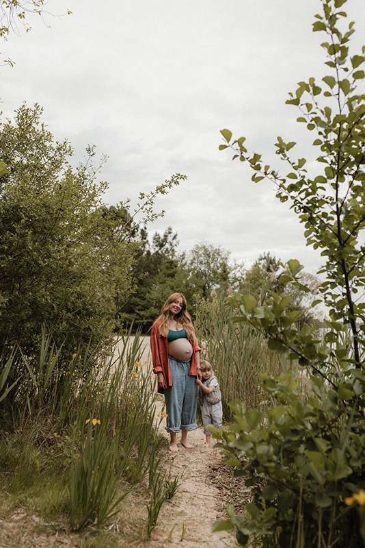 Une maman et sa fille se tiennent debout au milieu d'un petit chemin dans les roseaux.